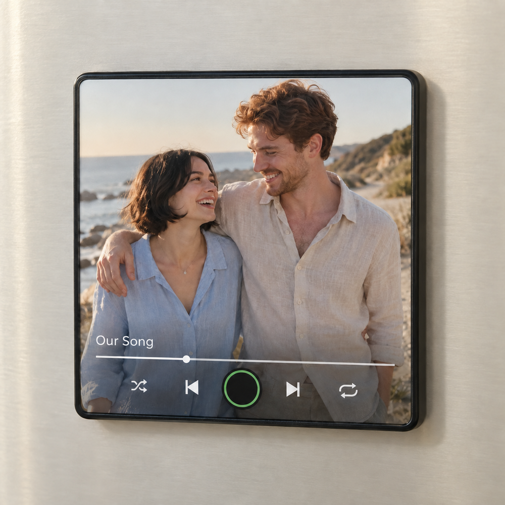 Black framed personalized couple photo music fridge magnet with a blank green-ringed button and smiling couple by the sea.