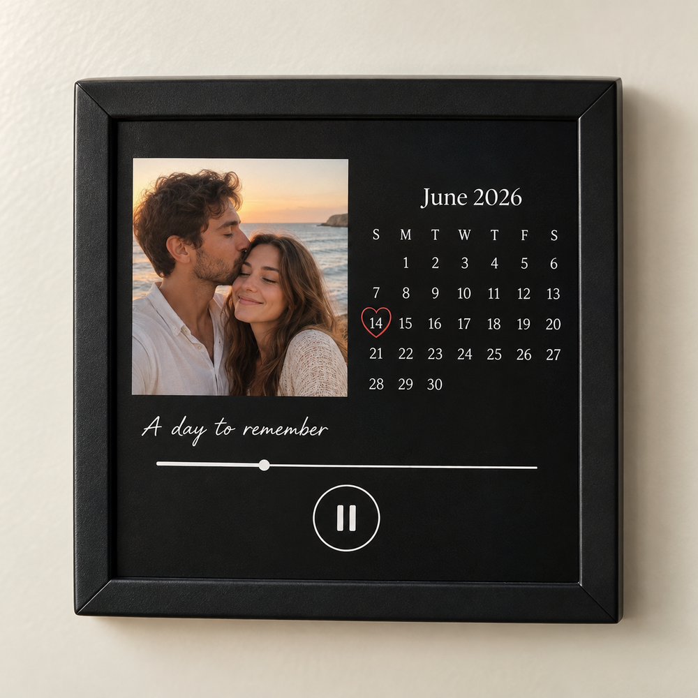 Black framed music fridge magnet with a seaside couple photo and June 2026 calendar marking June 14.